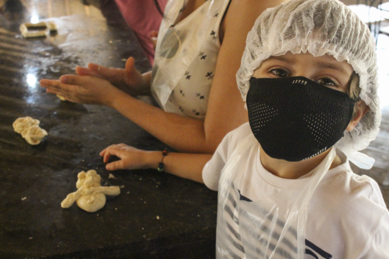 Criança mostrando o biscoito que fez no formato de coelhinho
